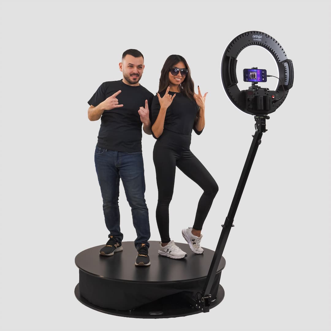 Man and woman using 360 photo booth hire at corporate event